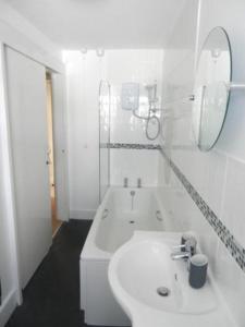 ein weißes Badezimmer mit einem Waschbecken und einer Badewanne in der Unterkunft 3 Prospect Place, New Quay, sleeps 6, parking, sea views, dog friendly in New Quay