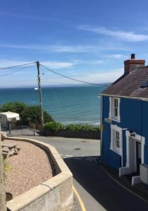 ein blaues Haus mit Meerblick in der Unterkunft 3 Prospect Place, New Quay, sleeps 6, parking, sea views, dog friendly in New Quay