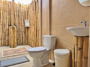 a bathroom with a toilet and a sink at La Tribu Boutique Hostel for women in Puerto Viejo