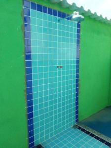 een betegelde badkamer met een blauwe en groene muur bij Restaurante e Pousada Peruaçu - Cozinha Caseira da Dona Ione in Fabião
