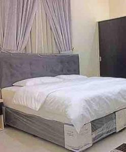 a bedroom with a bed with a white comforter and a window at Jameel Guest House in At-Tafilah