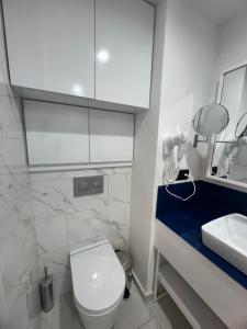 a bathroom with a white toilet and a sink at Orbi City HOTEL in Batumi