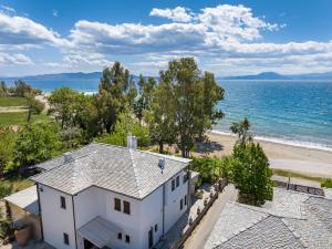 an aerial view of a white house and the beach at Iakovakis Seaside Exclusive Apartments in Koropi