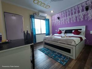 una camera con letto e parete viola di Mohit Paying Guest house a Varanasi