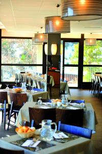 ein Restaurant mit Tischen und Stühlen, auf denen Essen steht in der Unterkunft VTF L'Ouka in Pra-Loup