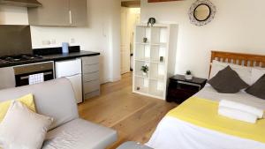 ein Schlafzimmer mit einem Bett und eine Küche mit einem Herd in der Unterkunft Kirkgate Aprt4 - Duplex Relocations in Wakefield