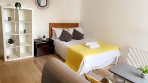ein Schlafzimmer mit einem Bett mit einer gelben Decke in der Unterkunft Kirkgate Aprt4 - Duplex Relocations in Wakefield