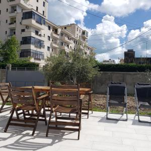 a patio with two chairs and a wooden table and chairs at Pomegranates & Olives Guesthouse in Durrës