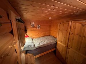 a small room with a bed in a log cabin at Traditional Norwegian log cabin with sauna by the sea in Tornes