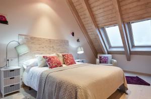 a bedroom with a large bed and two windows at Luderna - Casa Val de Ruda IV des Artiguetes in Baqueira-Beret