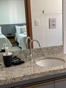 um balcão de casa de banho com um lavatório e um espelho em Studio 606 - Expetacular em Ribeirão Preto