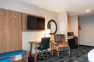 a room with a desk and a chair and a tv at Days Inn by Wyndham Troy in Troy