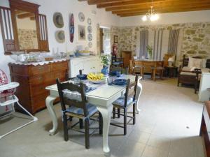 cocina y comedor con mesa y sillas en Villa Venetico stone retreat with garden, en Faneroméni