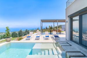 une maison avec une piscine avec des chaises longues dans l'établissement Villa Orion, à Tsoukaladhes