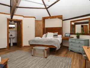 a bedroom with a bed and a vanity and a mirror at The Roundhouse in Okehampton