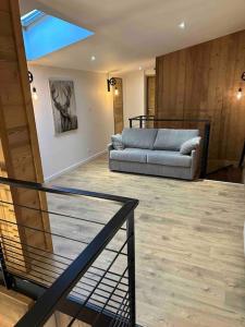 ein Wohnzimmer mit einer Couch und einer Treppe in der Unterkunft Spacieux et beau duplex au pied des pistes et centre station avec balcon in Les Deux Alpes