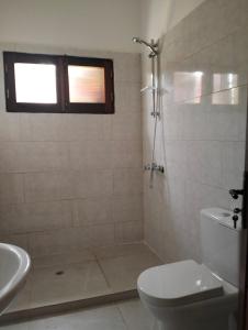 y baño con ducha, aseo y lavamanos. en Moradia Turistica MJ ROOMS CITY, en São Tomé