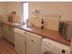 a kitchen with a counter top with a bottle of wine at Morwelir Llangrannog in Llangrannog