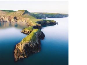 an island in the middle of a body of water at Morwelir Llangrannog in Llangrannog