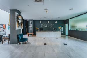 a lobby with a reception desk and a blue chair at Soho Playa Hotel in Playa del Carmen