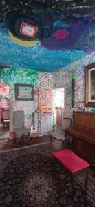 a room with a piano and a wall covered in graffiti at Multitudenow in Florianópolis