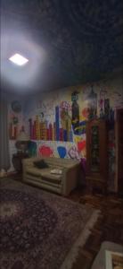 a living room with a bed and a wall covered in graffiti at Multitudenow in Florianópolis