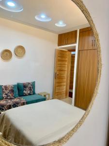 1 dormitorio con cama y espejo en Ocean Surf House, en Tamraght Ouzdar