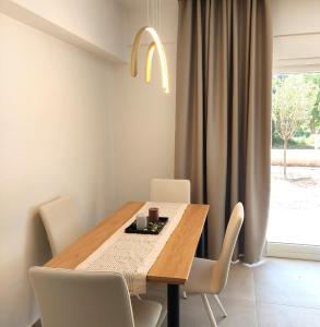 - une salle à manger avec une table et des chaises en bois dans l'établissement Athasi Resindences, à Thasos
