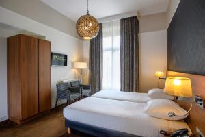 Postel nebo postele na pokoji v ubytování Parkhotel Valkenburg