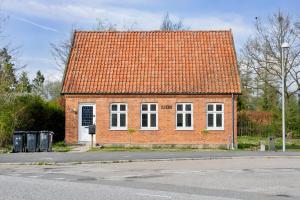 une petite maison en briques avec un toit orange dans l'établissement Town House in Fuglebjerg, à Fuglebjerg