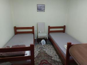two beds in a room with a table and a chair at Smeštaj Gokčanica in Gokčanica