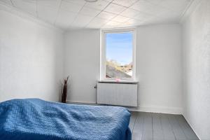 - une chambre avec un lit et une fenêtre dans l'établissement Town House in Fuglebjerg, à Fuglebjerg