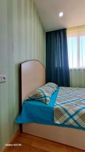 a bed in a bedroom with a blue curtain and a window at Best apartments in downtown in Yerevan