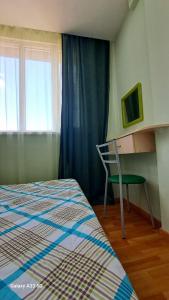 a bedroom with a bed and a chair and a window at Best apartments in downtown in Yerevan
