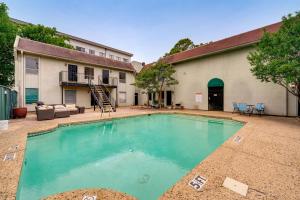 a swimming pool in front of a house at 4 Mi to Dtwn Dallas Condo with Pool Access! in Dallas