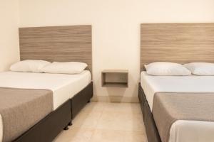 two beds in a hotel room with twothirdsessions at Hotel Inter del Café in Pereira +76 photos