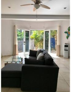 3AP Beachy 1 bedroom 1 Bath Pool Lrg Patio في San Carlos: غرفة معيشة مع أريكة سوداء وطاولة زجاجية