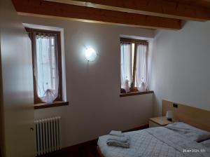 Un dormitorio pequeño con una cama y dos ventanas. en Riva City Heart, en Riva del Garda 20 fotos más