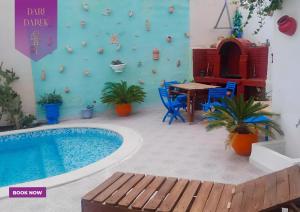 un patio con piscina, mesa y sillas en Verte Casa en Hammamet