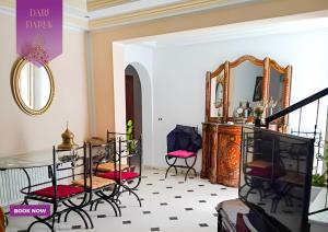 Habitación con sillas, mesa y espejo. en Verte Casa en Hammamet