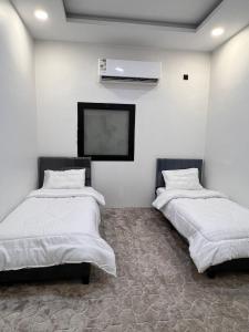 two beds in a room with a flat screen tv at استراحة غزل in Al Madinah