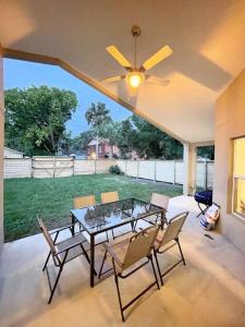 uma mesa de jantar com cadeiras e uma ventoinha de tecto em The Sanford Ave House with fully fenced yard em Sanford