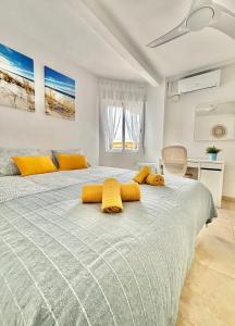 1 dormitorio con 1 cama grande y toallas amarillas. en VistaMar Bliss, en El Campello