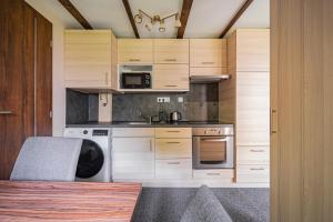 a kitchen with wooden cabinets and a sink and a stove at B48 Woodhause in Törökbálint