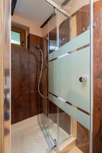 a shower with a glass door in a bathroom at B48 Gardenhouse - a zöldben kényelmesen in Törökbálint