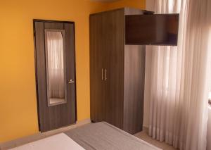a bedroom with a bed and a cabinet with a mirror at Hotel Inter del Café in Pereira