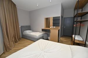 a hotel room with a bed and a desk and a bedroom at MondurO Hotel in Durrës