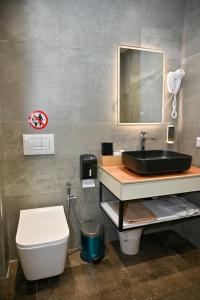 a bathroom with a sink and a toilet at MondurO Hotel in Durrës