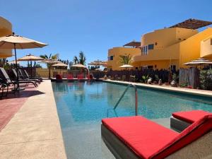 a swimming pool with chairs and umbrellas at a resort at 3B Cerritos Beach Condo, Lrg Pool, Baja Sur in San Carlos