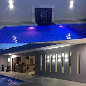 a swimming pool with lights in a house at RECANTO DA LU in Maringá